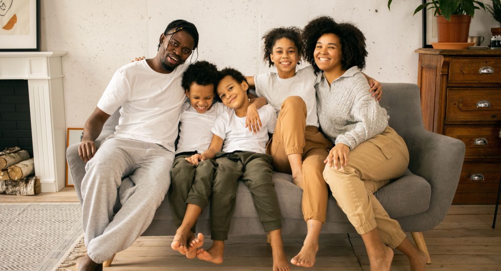 Colorado family standing outside their home, illustrating the opportunity and stability created through affordable homeownership.
